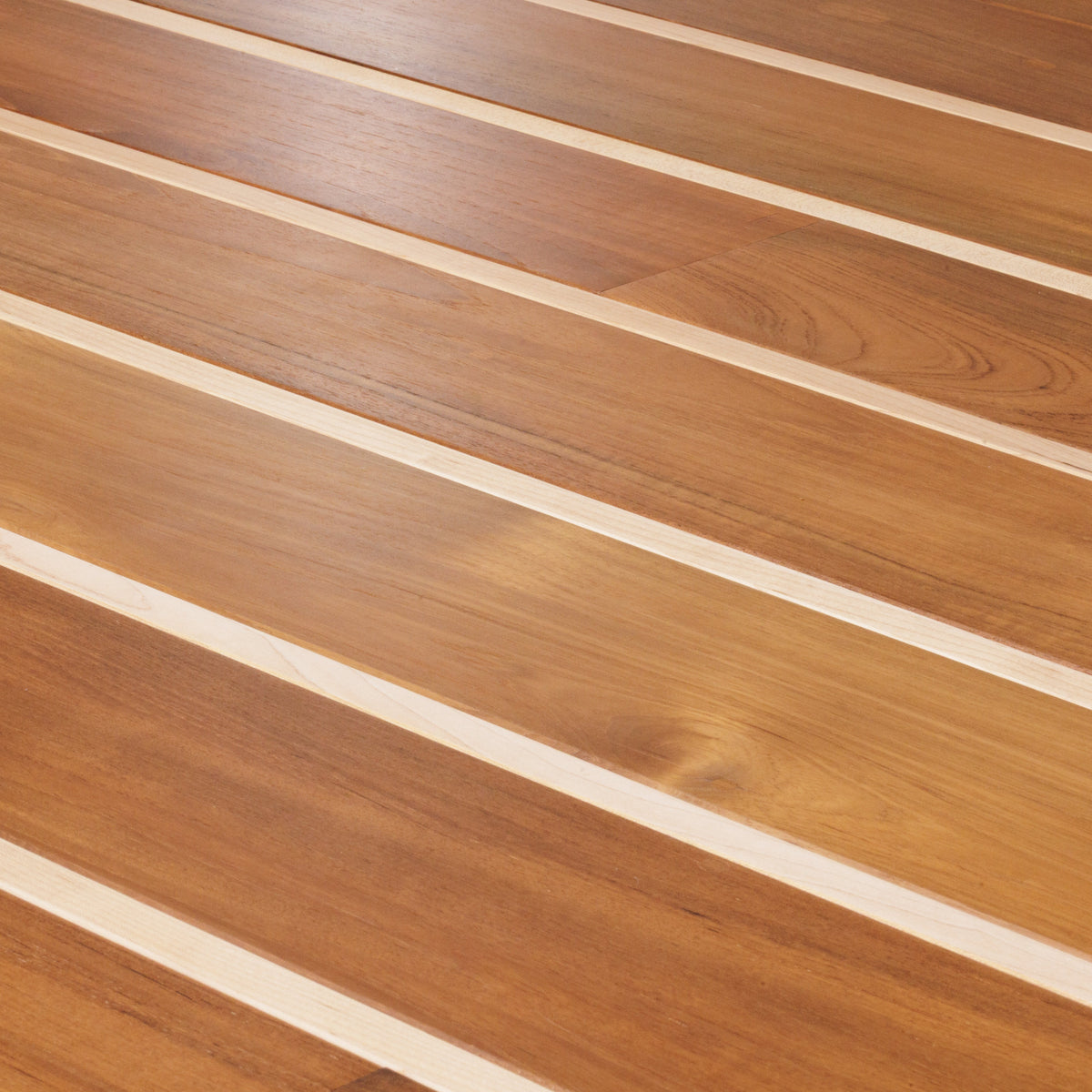 Oblique close-up of warm brown wood boards divided by narrow pale strips