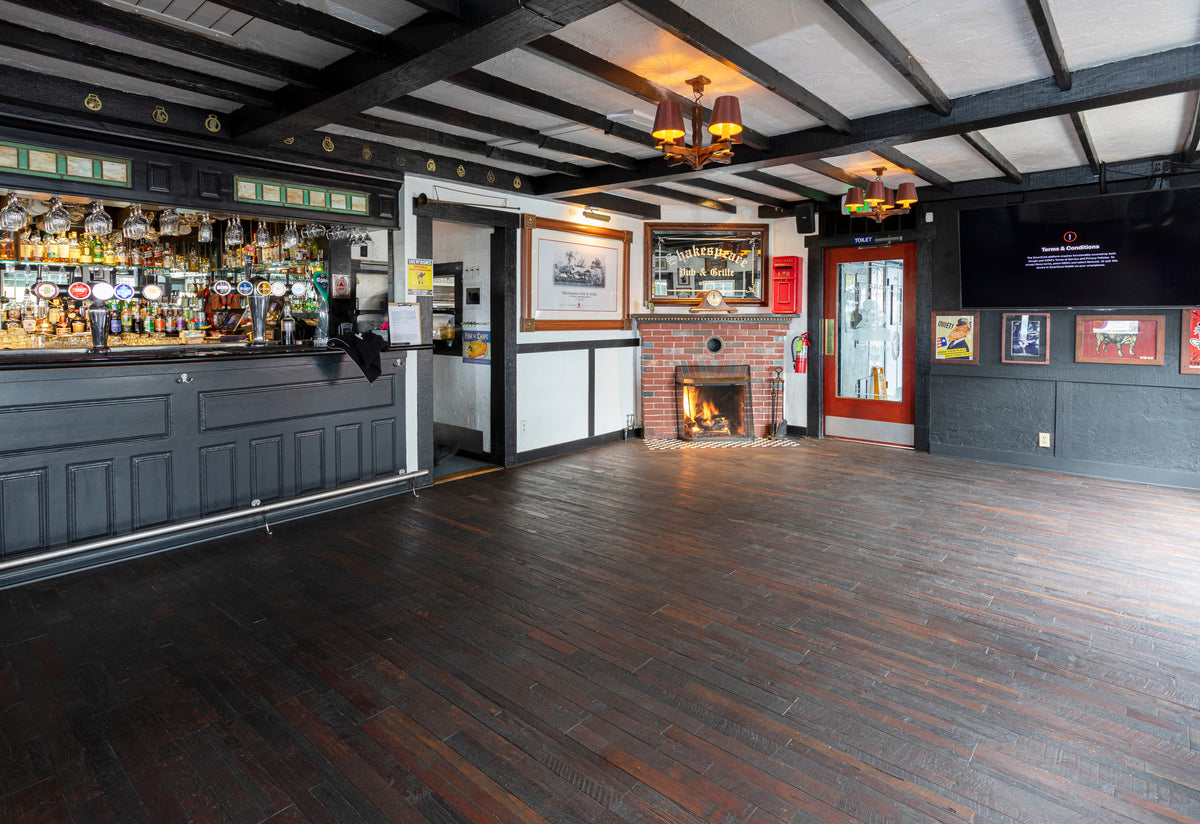 Pub bar with dark cabinetry and textured brown plank flooring