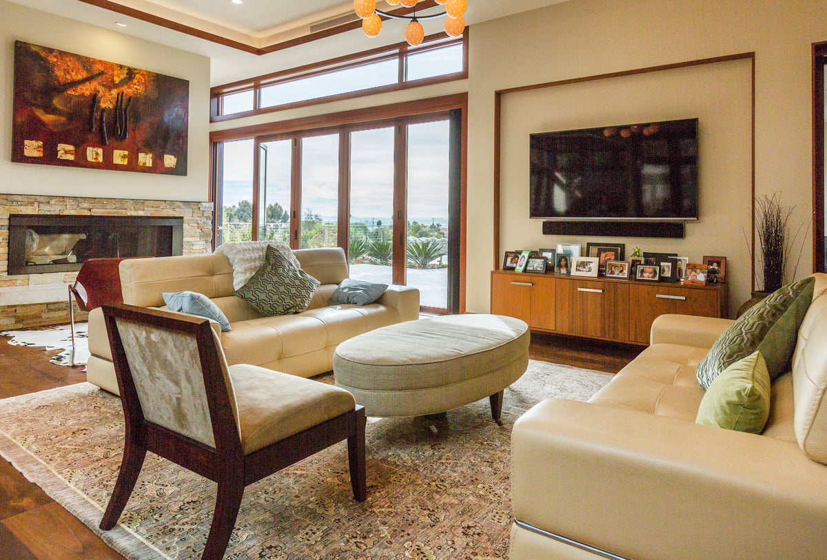 Living room with timber-framed windows, chairs, rug, and brown wood flooring