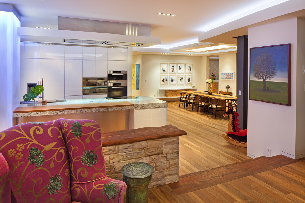 Kitchen and dining room with brown plank flooring and colorful upholstered chair
