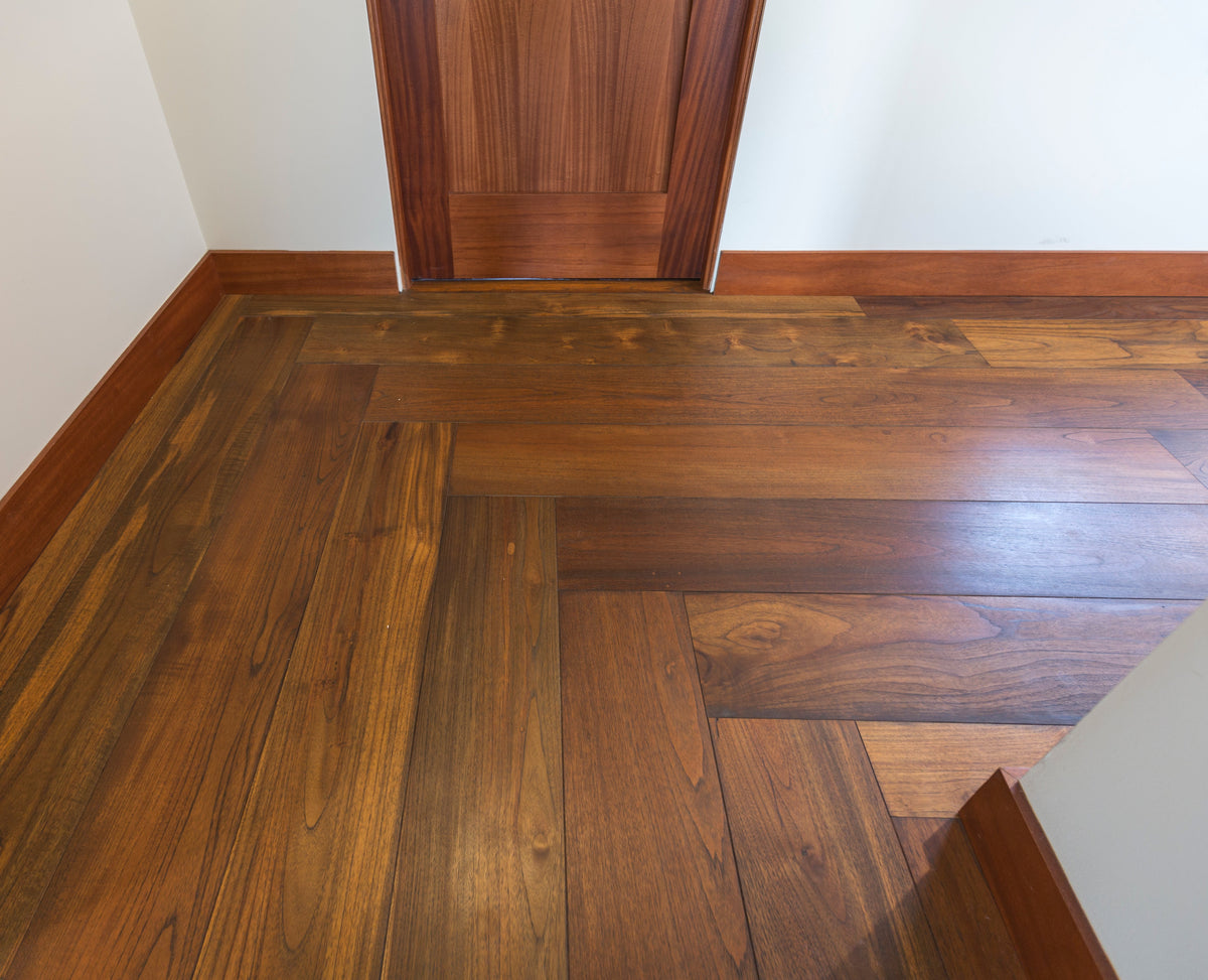 Wood floor detail at a doorway, with visible grain and a change in board direction
