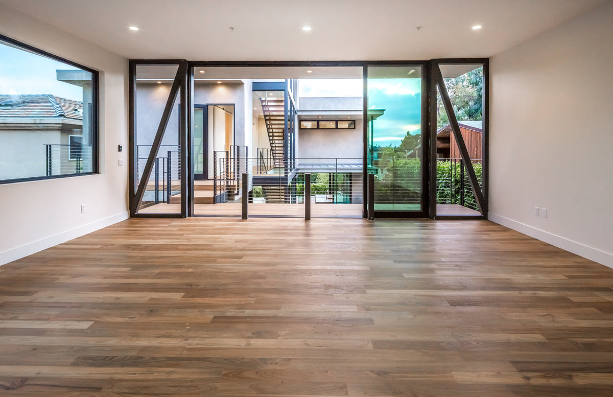 A wood-floored room opens through large doors toward an exterior court and stairs
