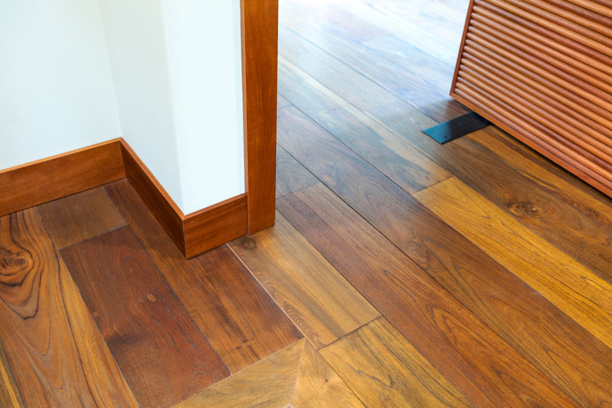 Close view of varied wide wood boards beside a doorway and slatted cabinet