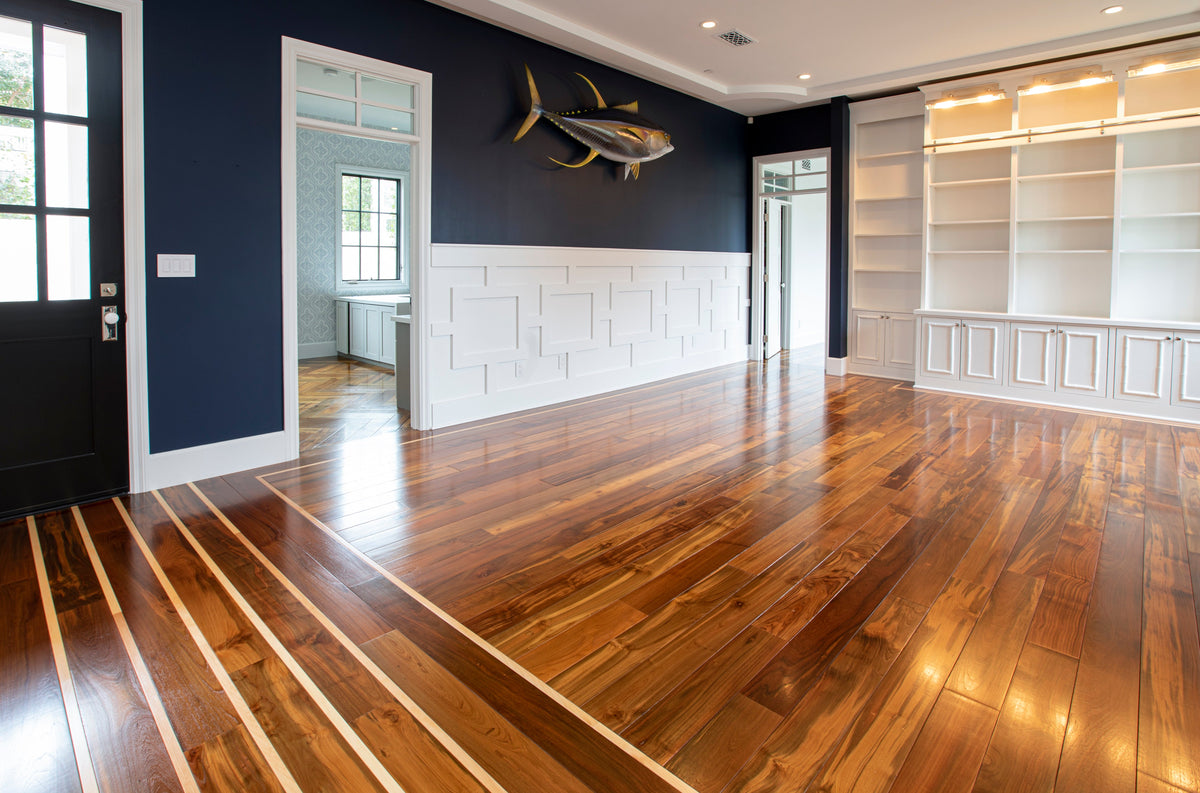 Navy walls and white trim beside striped wood flooring meeting a plain wood floor