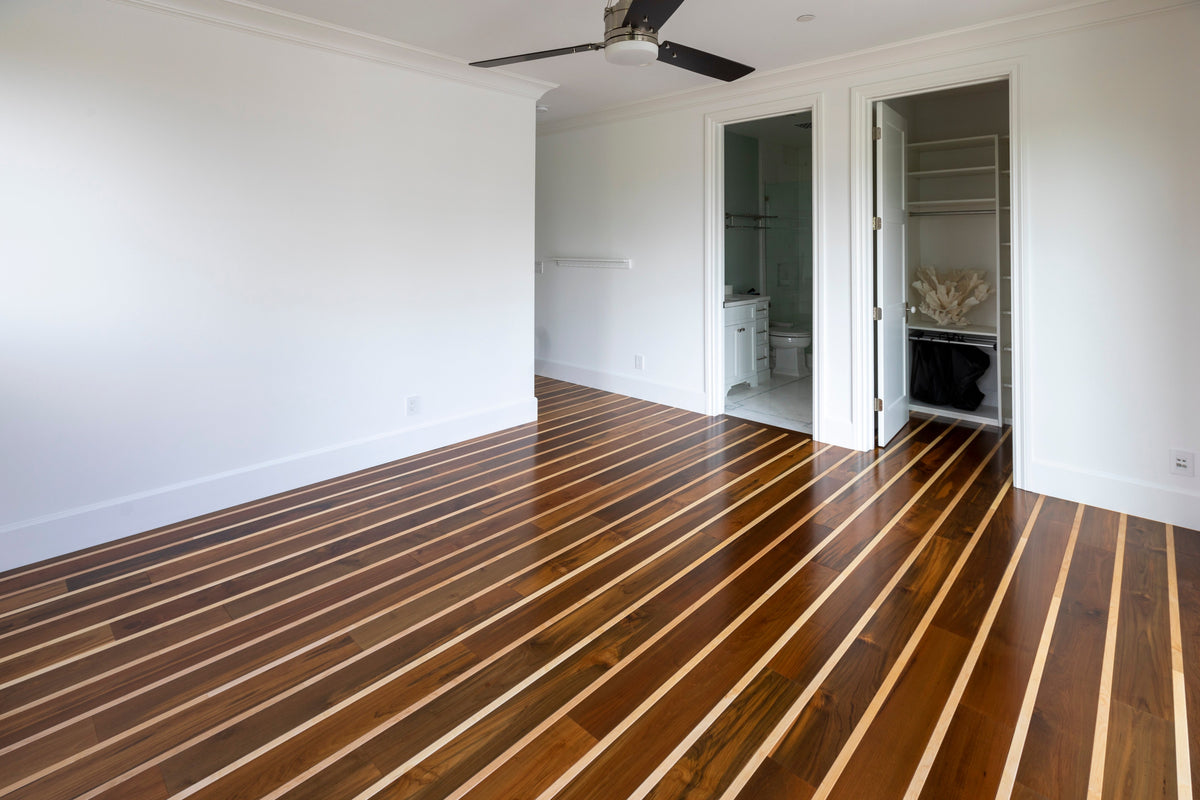 Unfurnished white room with striped wood flooring and two open doorways