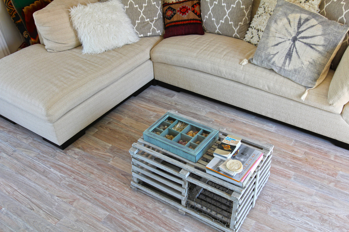 Light upholstered seating and patterned cushions beside pale wood flooring