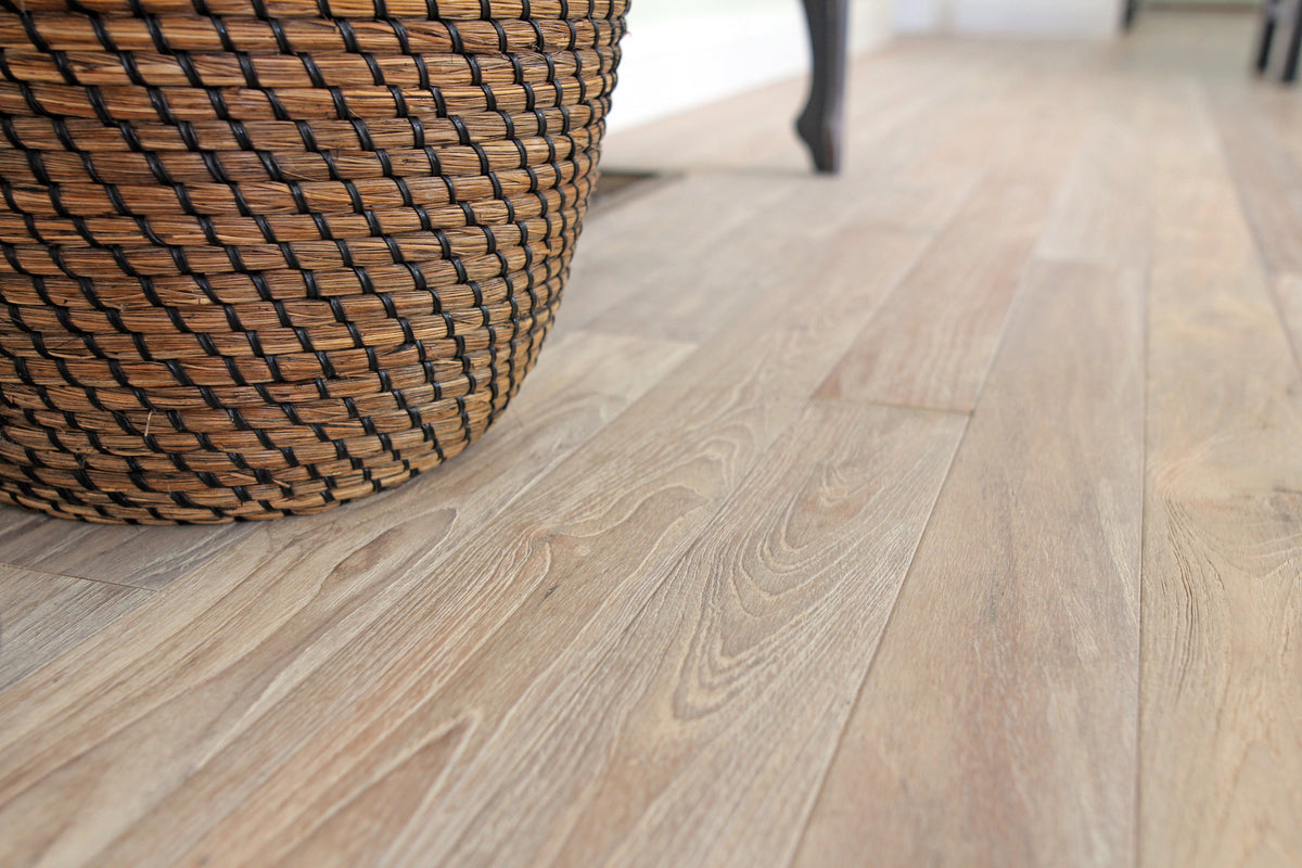 Close view of pale wood floorboards beside a woven basket