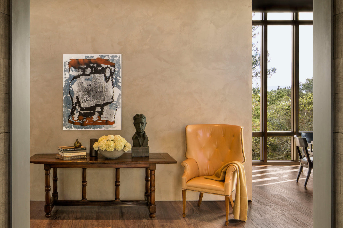Wood floor and adjoining doorway beneath a console table and yellow chair